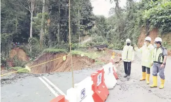  ?? — File photo ?? Fadillah (middle) inspecting a road that had collapsed.