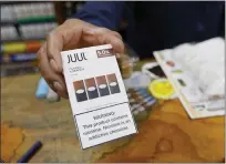  ?? SAMANTHA MALDONADO — THE ASSOCIATED PRESS ?? In 2019, a cashier displays a packet of tobacco-flavored Juul pods at a store in San Francisco.