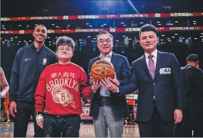  ?? THE BROOKLYN NETS ?? China’s Consul General in New York Huang Ping (second from right), founder of Wah Yan Ching Nin clothing brand Wang Peng (third from right), and CEO of Venturant Group Liao Yu (right) tip off the ball for the Brooklyn Nets’ Chinese New Year game at Barclays Center on Feb 13.