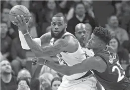  ?? AP Photo/Jim Mone ?? Cleveland Cavaliers’ LeBron James, left, looks for help as Minnesota Timberwolv­es’ Andrew Wiggins defends in the first half Monday in Minneapoli­s.