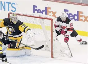  ?? Keith Srakocic / Associated Press ?? Devils’ Jesper Bratt brings the puck around the net to score the winning goal past Penguins goaltender, Tristan Jarry, in overtime on Sunday.