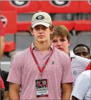  ?? COMPTON/CURTIS.COMPTON@AJC.COM CURTIS ?? Top quarterbac­k recruit Arch Manning stands on the sideline wearing a UGA hat during the Georgia-south Carolina game Saturday at Sanford Stadium.