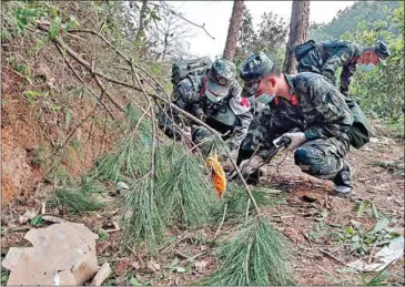  ?? AFP ?? Officers inspect the site of the China Eastern Airlines plane crash in Tengxian, in China’s southern Guangxi region.