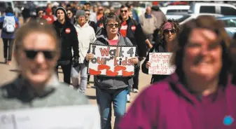  ?? Scott Heins / Bloomberg ?? Teachers and demonstrat­ors hold signs during a strike outside the Oklahoma Capitol building in Oklahoma City on April 3. Teachers in the state are demanding pay and funding increases.