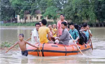  ?? — Reuters ?? Flood-affected villagers are moved to a safer place after heavy rains at Mogpara, south of Agartala, on Wednesday.