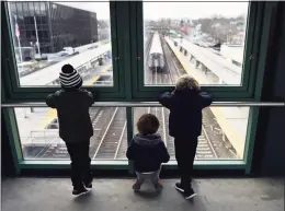  ??  ?? A group of kids watch as a train passes through the Metro-North station in Greenwich on Tuesday.