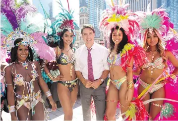  ?? CHRIS YOUNG / THE CANADIAN PRESS ?? Prime Minister Justin Trudeau stops for a photo with dancers from the Toronto Caribbean Carnival on Friday.