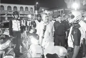  ??  ?? KETUA Polis Negara Tan Sri Khalid Abu Bakar bertanya khabar kepada Anggota Rondaan Bermotosik­al (URB) PDRM ketika beliau menghadiri program ‘Nur Ramadan’ Singgah Sahur Warga PDRM Perak di Balai Polis Pekan Baru kelmarin.