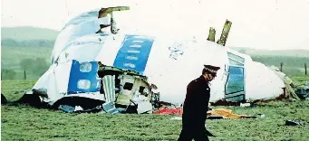  ?? AP African News Agency (ANA) ?? A POLICE officer walks by the nose of Pan Am flight 103 in a field near the town of Lockerbie, Scotland where it lay after a bomb aboard exploded, killing a total of 270 people, in this December 21, 1988 file photo. |