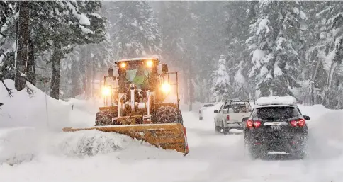  ??  ?? Snow is cleared from a residentia­l road during a winter storm in Incline Village, Nevada, US. — Reuters photo
