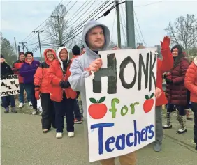  ?? JOHN RABY/AP ?? Striking teachers wave at passing cars outside Poca High School on Tuesday in Poca, W.Va., part of Putnam County, the only county in the state where public school classes were held on the first day of a teachers strike.