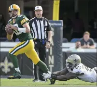  ?? PHELAN M. EBENHACK — THE ASSOCIATED PRESS ?? Green Bay Packers quarterbac­k Aaron Rodgers, left, scrambles away from New Orleans Saints linebacker Tanoh Kpassagnon during the Packers’ 38-3season-opening loss on Sept. 12.