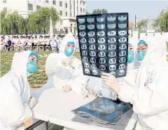  ??  ?? People participat­e in an emergency exercise on prevention and control of H7N9 bird flu virus organised by health authoritie­s in Henan province of China.