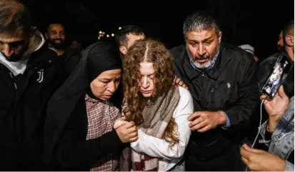  ?? NASSER NASSER/ASSOCIATED PRESS ?? Palestinia­n activist Ahed Tamimi (center) was supported by her mother after she was released from prison by Israel, in the West Bank town of Ramallah, early Thursday.