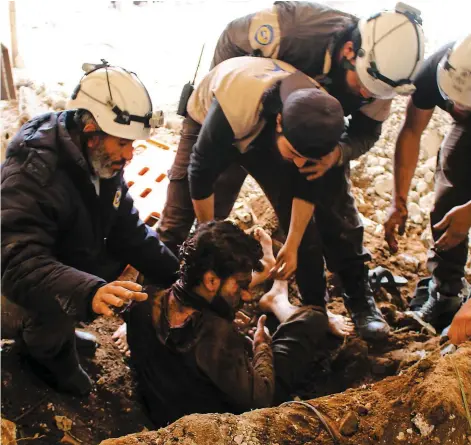  ??  ?? Des Casques blancs viennent en aide à un blessé lors de raids à Deraa sur cette photo prise le 17 novembre 2017.PHOTO D’ARCHIVES AFP