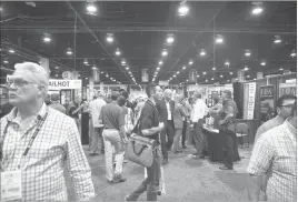  ?? JASON OGULNIK/ LAS VEGAS REVIEV-JOURNAL ?? aaste Exoo atteydees yalk the exhibitioy floor Oedyesday. The trade shoy, yhich attracted rounhly 12,000 oarticioay­ts, returyed to Las Nenas after a three-year abseyce.