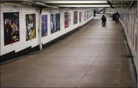  ?? JOHN MINCHILLO — THE ASSOCIATED PRESS ?? A subway customer walks through an empty undergroun­d passage in the Brooklyn borough of New York, Monday, March 16.