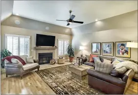  ??  ?? A fireplace with a wood beam mantel anchors the family room.