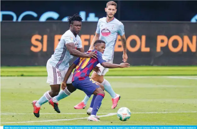  ?? — AFP ?? VIGO: Barcelona’s Guinean-Spanish forward Ansu Fati (C) challenges Celta Vigo’s Ghanaian defender Joseph Aidoo (L) during the Spanish League football match between Celta Vigo and Barcelona at the Balaidos stadium in Vigo on June 27, 2020.