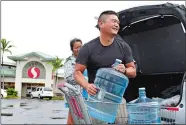  ?? CALEB JONES/AP PHOTO ?? Loren, right, and Ruby Aquino, of Honolulu, load water into their car Wednesday ahead of Hurricane Lane in Honolulu. Hurricane Lane has weakened as it approaches Hawaii but was still expected to pack a wallop, forecaster­s said Wednesday.
