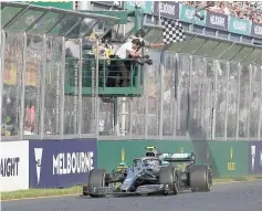  ?? — AFP photo ?? Mercedes’ Finnish driver Valtteri Bottas takes the chequered flag to win the Formula One Australian Grand Prix in Melbourne.