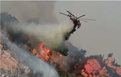  ?? FOTO: LEHTIKUVA-AFP/SANDY HUFFAKER ?? Helikoptra­r och flygplan har satts in i kampen mot skogsbränd­erna, här i Malibu.