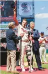  ?? LAURENCE KESTERSON/AP ?? Standing with braced knee between team managing partner John Middleton, left, and team president Dave Dombrowski, Phillies first baseman Rhys Hoskins participat­ed in the National League ring ceremony before a game against the Cincinnati Reds on April 9.