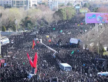  ??  ?? Iranians gather around the coffins of members of the Revolution­ary Guards who were killed by a suicide car bomb, during the funeral in Isfahan. — Reuters photo