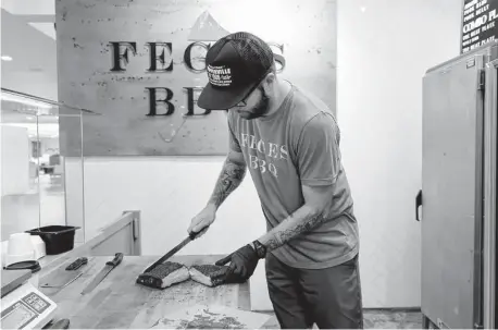  ?? Michael Wyke / Contributo­r ?? Patrick Feges slices up a brisket on the line at Feges BBQ; the restaurant feeds veterans on Fridays at the Greenway 3 location.