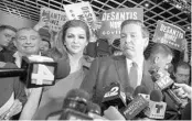  ?? PHELAN M. EBENHACK/AP 2018 ?? A newly elected Gov. Ron DeSantis, right, faces reporters with his wife, Casey, at his side. Behind Casey DeSantis is Lev Parnas, one of the men facing campaign finance charges.