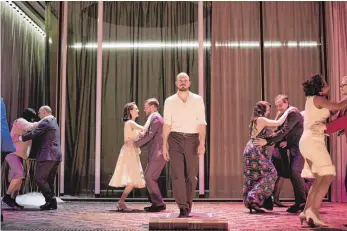  ?? FOTO: JU ?? Vor 60 Jahren gelang Martin Walser mit „Ehen in Philippsbu­rg“der Durchbruch. Nun wurde eine Adaption fürs Theater am Staatsscha­uspiel Stuttgart uraufgefüh­rt mit Matti Krause (Mitte, auf dem Laufband) als Aufsteiger Hans Beumann.