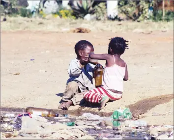  ??  ?? Barefoot children play with dirty water at Matapi Flats in Mbare, Harare, exposing themselves to health hazards yesterday. — (Picture by Tariro Kamangira)