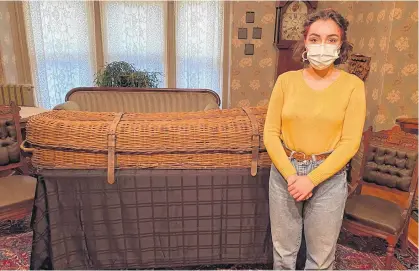  ?? CONTRIBUTE­D ?? Tour guide Olivia MacPhail stands beside a cooling casket on the second floor of the Beaconsfie­ld Historic House in Charlottet­own. During the second half of the 19th century, the deceased would be placed into a cooling casket before being moved into a real casket.