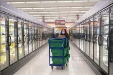  ?? Emily Matthews/Post-Gazette ?? Karen Gallagher, of Brookline, walks down the frozen foods aisle while she picks out items for an order Wednesday at the Parkway Center Giant Eagle in Green Tree.