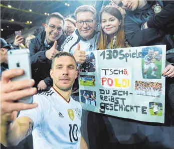  ?? FOTO: DPA ?? Das letzte Mal Podolski für Deutschlan­d, das sollte gewürdigt werden: Lukas Podolski fotografie­rt sich, seine Fans und die Abschiedsg­eschenke.