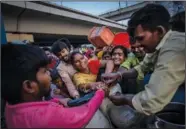  ?? ?? People living in temporary shelter jostle for drinking water Sept. 29 from a municipali­ty water tanker after they evacuated.