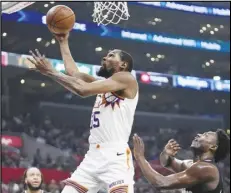  ?? Associated Press ?? Phoenix Suns forward Kevin Durant (left) shoots as Clippers guard Kobe Brown defends during the first half of an NBA basketball game on Wednesday in Los Angeles.