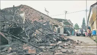  ?? ?? Residents near a house flattened by an earthquake that struck Cianjur in Indonesia’s densely populated island of West Java on Monday.