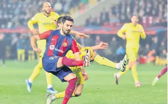  ?? — AFP photo ?? Gundogan kicks the ball during the Spanish league football match between FC Barcelona and Villarreal CF at the Estadi Olimpic Lluis Companys in Barcelona.