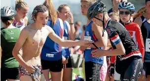  ?? PHOTO: ROBYN EDIE/FAIRFAX NZ ?? Southland Boys’ High school students Jackson Herrick, left, after the swim, passing the transponde­r on to team-mate Quinn Naylor, for the bike leg at the Southland Secondary Schools Triathlon Champs held at Central Southland College.
