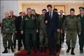  ?? (SANA via AP) ?? Syrian President Bashar Assad (center right) speaks with Russian Defense Minister Sergei Shoigu (center left) on Monday before their meeting in Damascus, Syria.