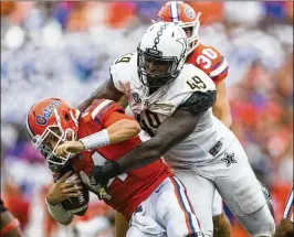  ?? ALAN YOUNGBLOOD / THE GAINESVILL­E SUN ?? Florida quarterbac­k Luke Del Rio (14) is sacked by Vanderbilt defensive end Jonathan Wynn during the first half Saturday in Gainesvill­e. Del Rio was injured on a subsequent play when knocked down after releasing a pass.