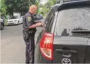  ?? Contribute­d photo ?? Fairfield Police Officer Jeff Wikman hands out a ticket during a distracted driving enforcemen­t campaign in 2017.