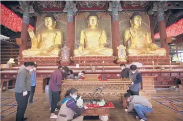  ?? AHN YOUNG-JOON/AP ?? People in face masks arrange desks during a cleanup at Jogye Temple in Seoul, South Korea, last month. South Korea has seen a rise in inoculatio­ns over the past few weeks as the Asia-Pacific region struggles to eradicate the virus.