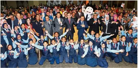  ??  ?? Loke and Dr Maszlee (second row, middle) launch the revised road safety module for primary schools.