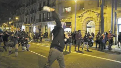  ?? Elisenda Pons ?? Algunos manifestan­tes vuelcan un contenedor de vidrio y cogen botellas para lanzarlas a la policia, anoche,