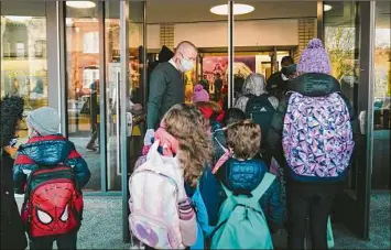  ?? Erin Schaff / New York Times ?? Brigham Kiplinger, principal at Garrison Elementary School in Washington, greets students as they arrive. Getting more young school-age children vaccinated is crucial for ending the pandemic, public health officials say, and many are focusing on that group.