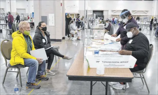  ?? Nam Y. Huh The Associated Press ?? Election workers, right, verify ballots as recount observers watch Friday during a hand recount of votes in Milwaukee. President Donald Trump requested the recount in two heavily liberal counties.