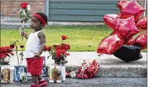  ?? LYNDA M. GONZALEZ / AMERICAN-STATESMAN ?? Ty’Re Brown, 1, adds flowers to a memorial for Devonte Ortiz at the apartments where police say Jason Roche fatally shot the 19-yearold in a dispute over fireworks.