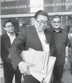  ??  ?? Huan (centre) carrying documents to be presented to MACC. — Bernama photo